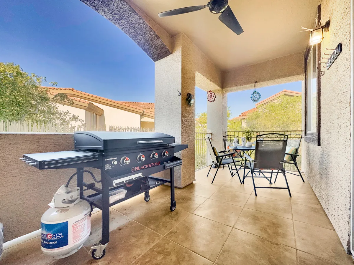 An outdoor dining setup on the balcony, complete with a grill, table, and chairs. The scene captures the potential for al fresco dining and socializing against a scenic backdrop, inviting guests to enjoy meals outdoors with views.