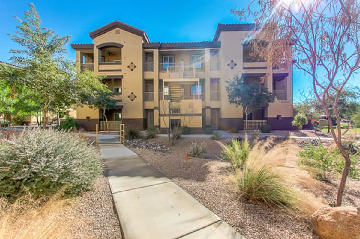 This exterior image showcases the main building structure surrounded by a landscaped pathway and vibrant greenery. The scene is inviting, with open walkways that hint at opportunities for leisure strolls and community gatherings, reflecting a sense of relaxation and togetherness that fits group getaways.